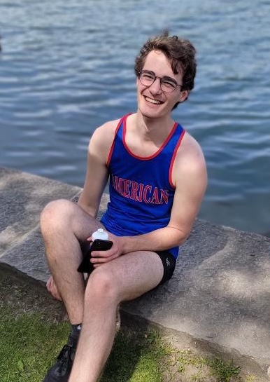 Collin Coil in front of the water in AU rowing team uniform