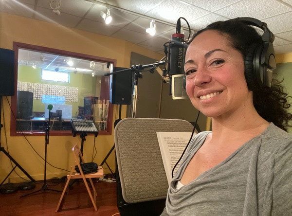Selfie of Jennifer Hamady in recording booth next to microphone