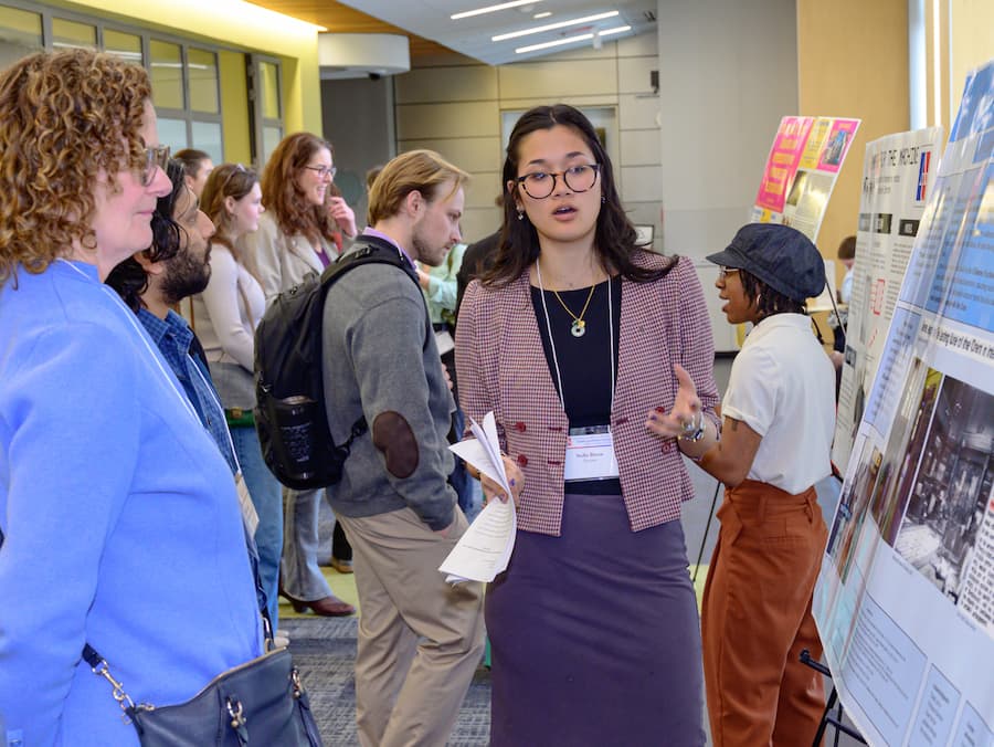 Students and attendees discussing posters.