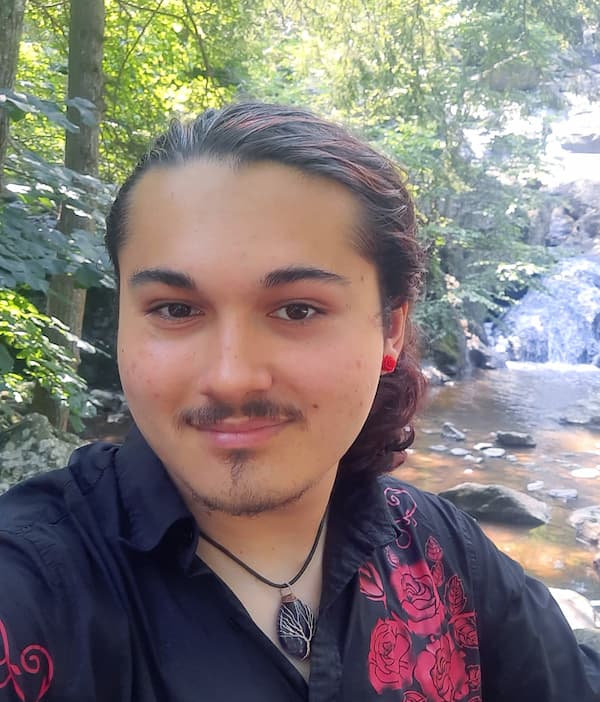 Person with woods and rocky cascade behind.