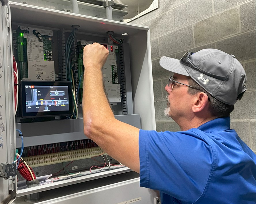 A facilities technician working on the building automation system.