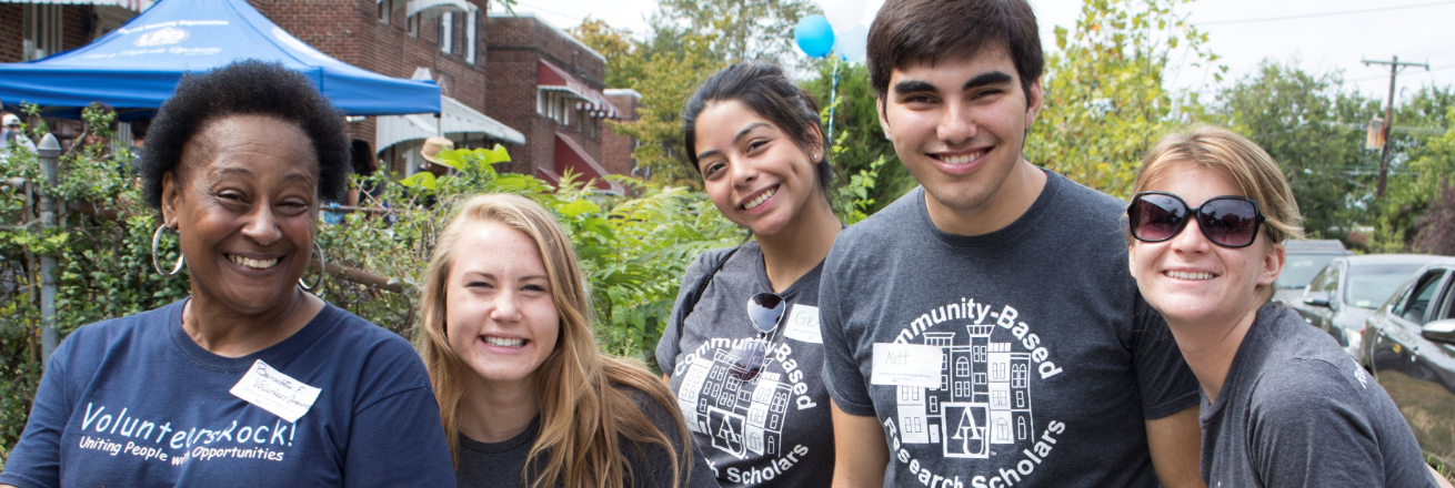 Group of 5 smiling volunteers in a neighborhood