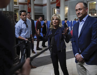 Michael LaRosa stands behind Jill Biden and Doug Emhoff near press scrum