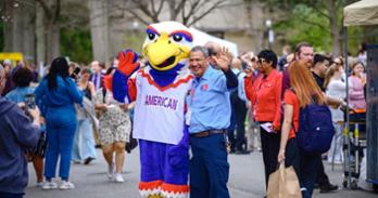 An AU staff member with Clawed Z. Eagle at a picnic after the inauguration ceremony. Photo by Jeff Watts.