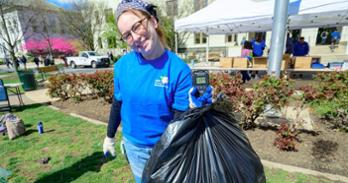 An AU community member holds up a trash bag on the quad. Photo by Jeff Watts.