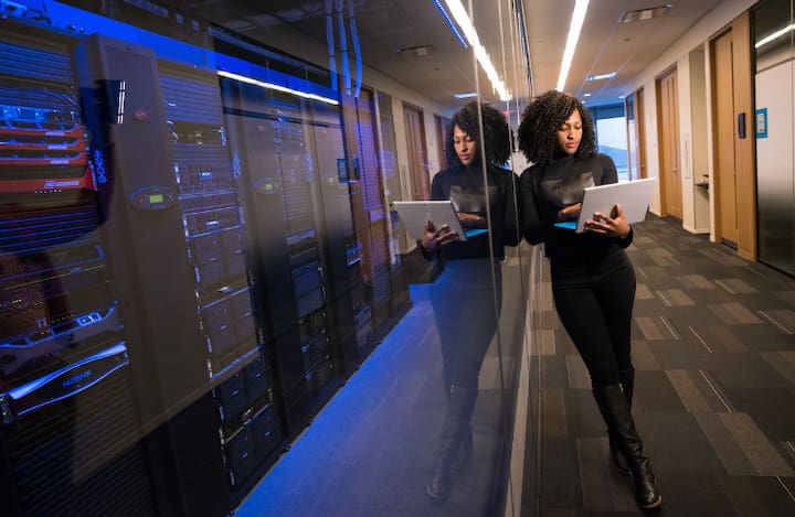 Woman with laptop near server racks