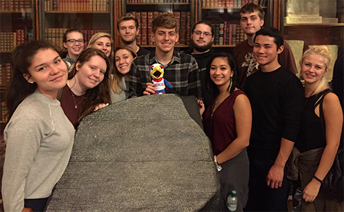 Students gathered around the Rosetta Stone