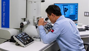 Student looking into an electric microscope