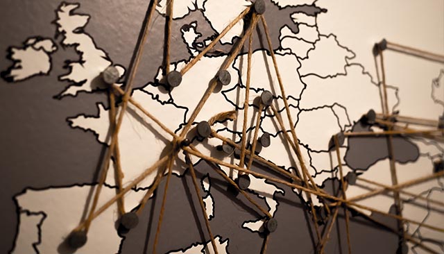 world map marked with string connecting pushpins