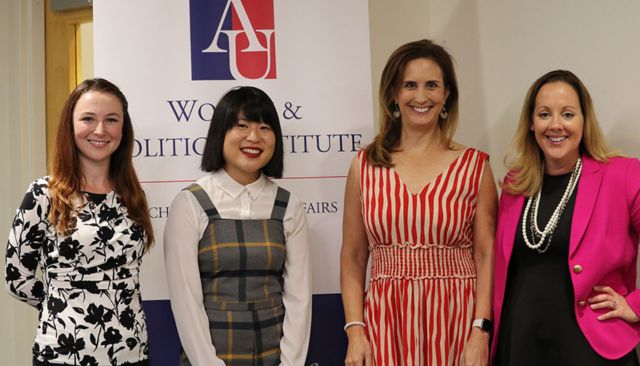 A group of panelists stand together for a photo