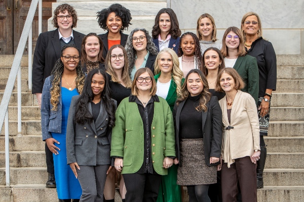 18 professional women standing in a group outside of a building