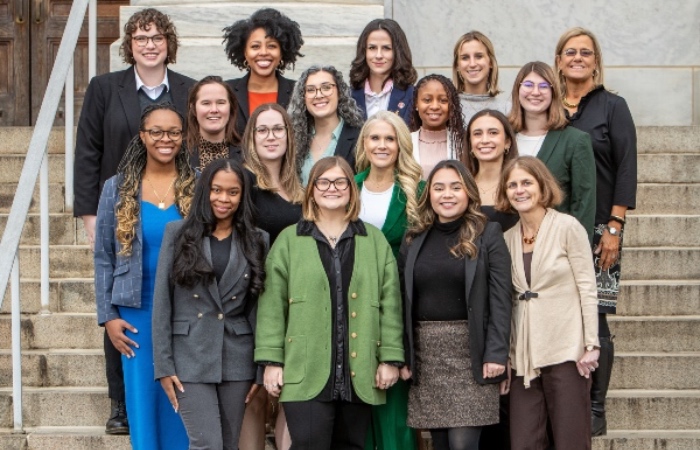 18 professional women standing in a group outside of a building