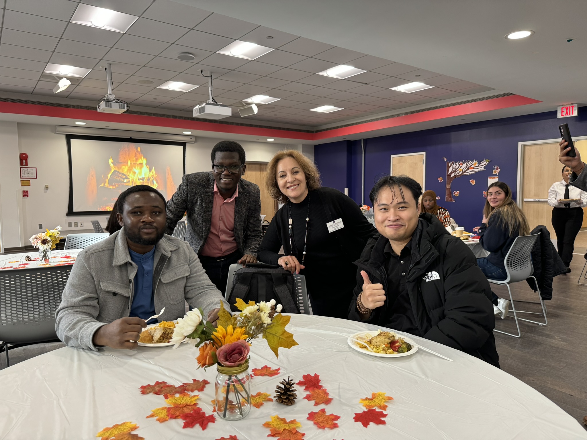 ISSS Director posing with international students at the Autumn Feast event