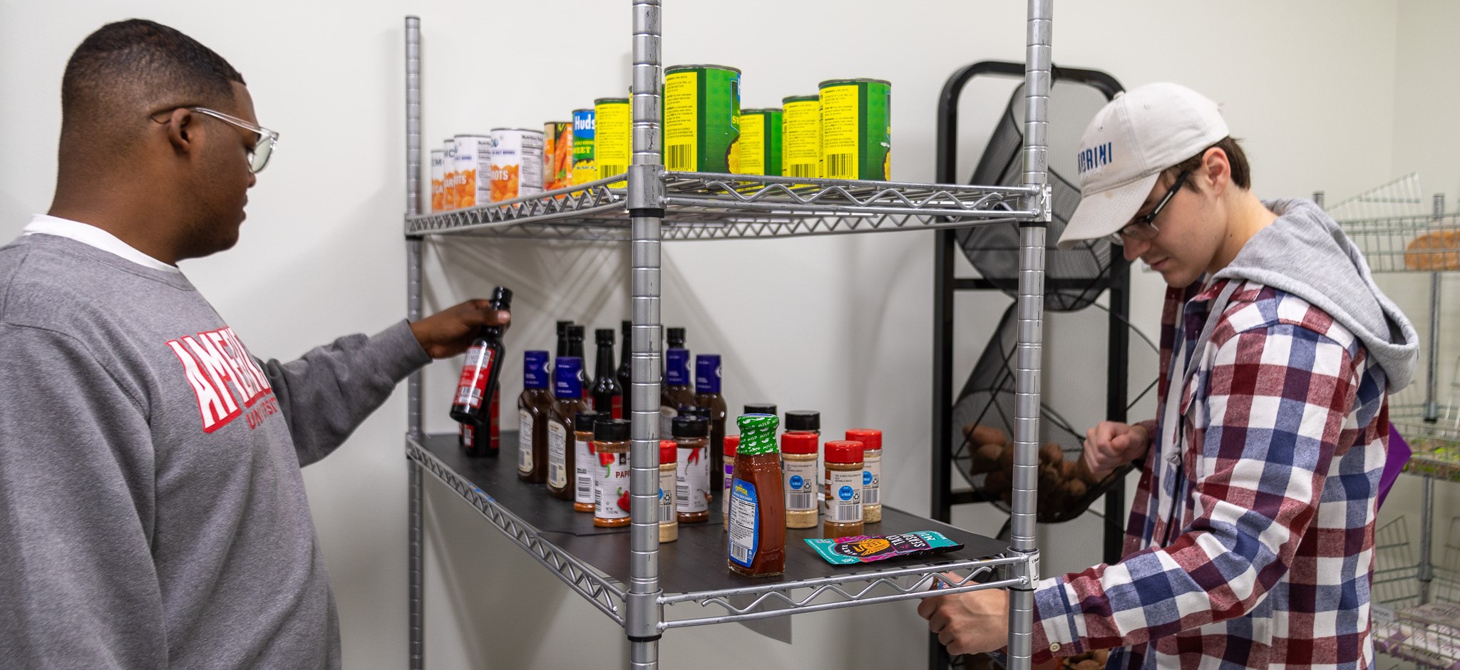 Two students consider cans and sauces in the Market, AU's food pantry.